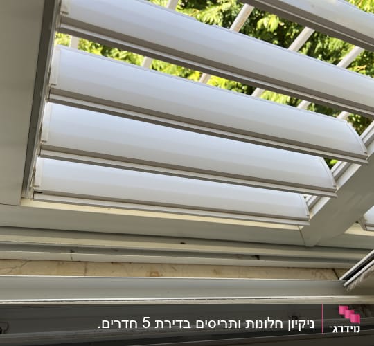 תריסים לבנים פתוחים עם מסגרת מתכתית